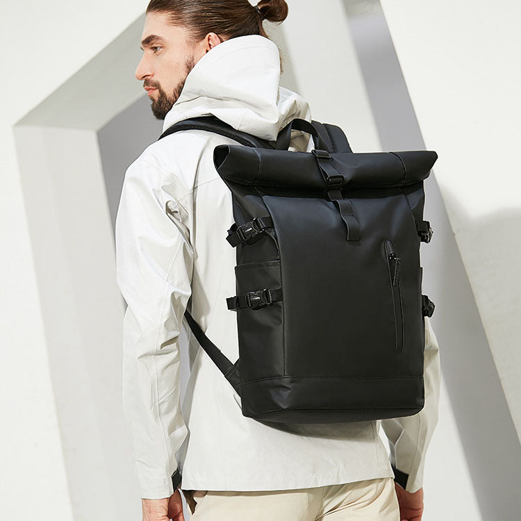 Man wearing the black waterproof laptop travel backpack outdoors