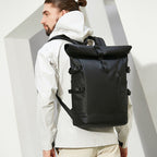 Man wearing the black waterproof laptop travel backpack outdoors
