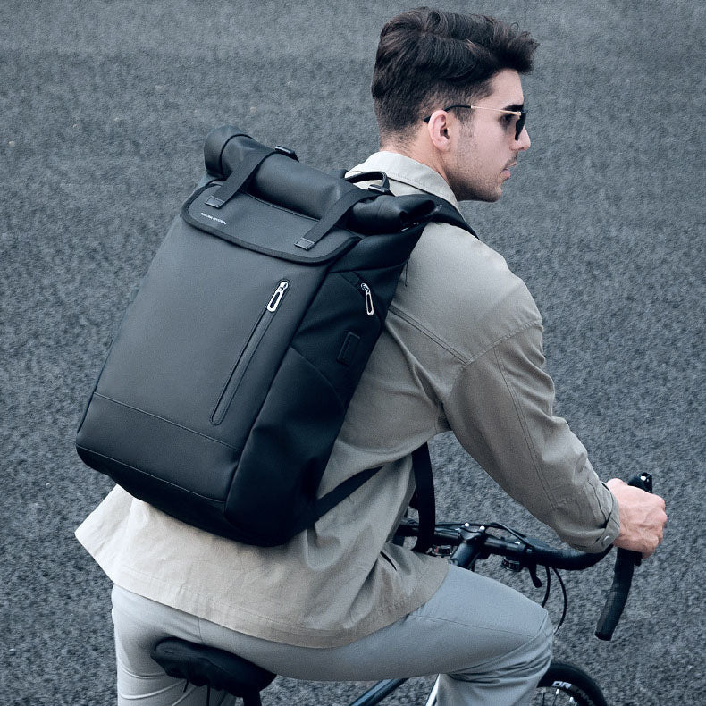 Cyclist wearing the durable ballistic Oxford roll-top ride backpack during an outdoor weekend travel trip.