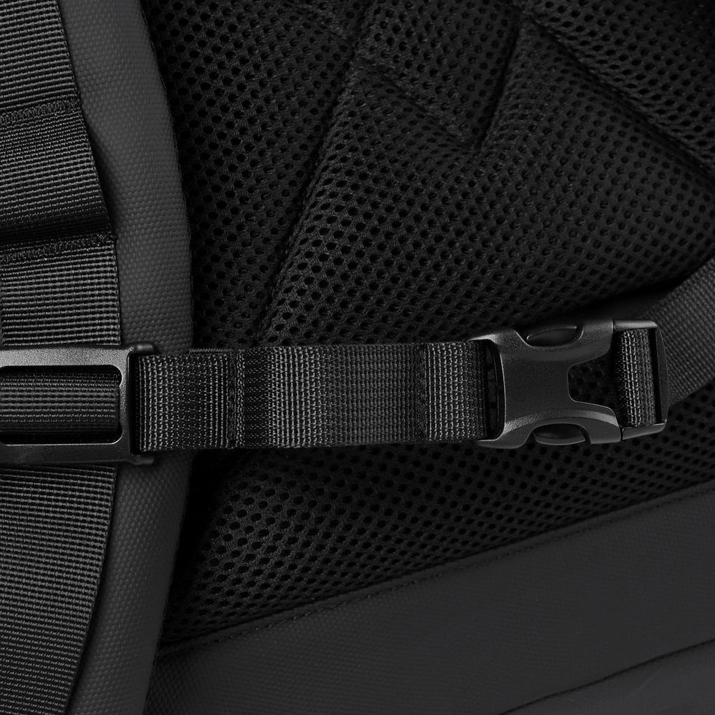 A close-up of the chest strap buckle on a black roll-top commuter backpack.