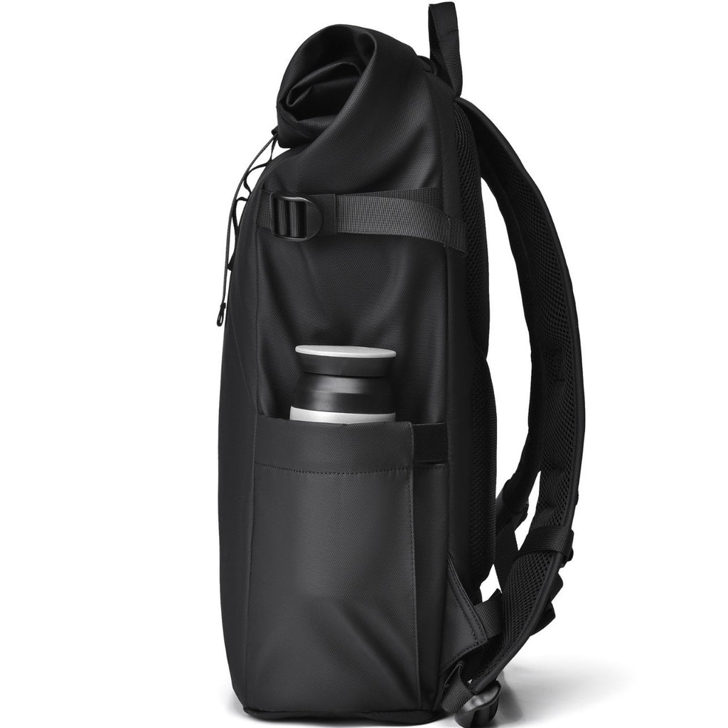 Close-up of the side pocket of a black roll-top commuter backpack holding a water bottle.